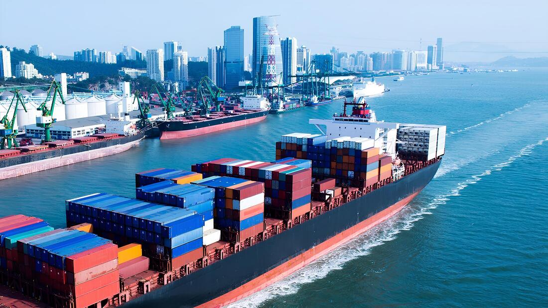 Container ship from Shenzhen at the port with cranes and the city in the background